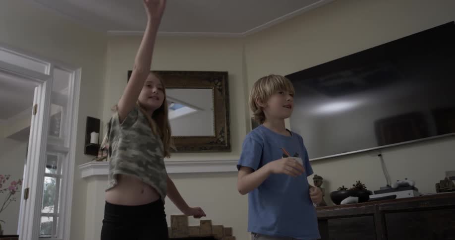 Two children create and throw paper airplanes from a table