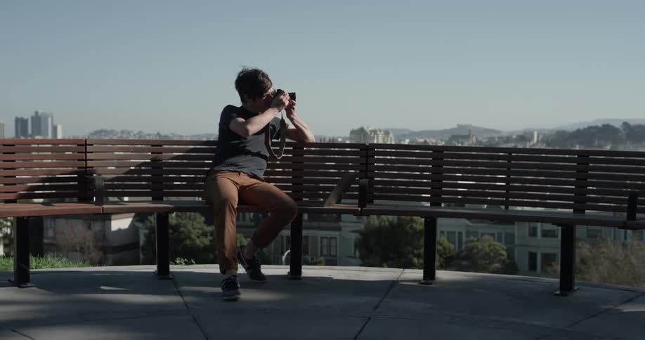 Man using a camera to take photos of a city