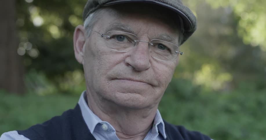 An old man has a disapproving expression on his face
