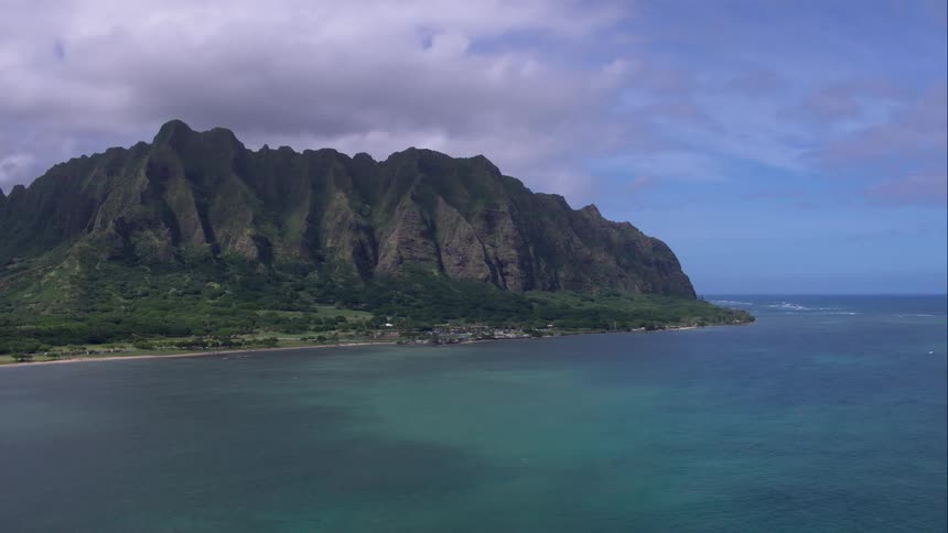 Beautiful landscape of the ocean and mountains with plenty of trees and clouds and blue skies