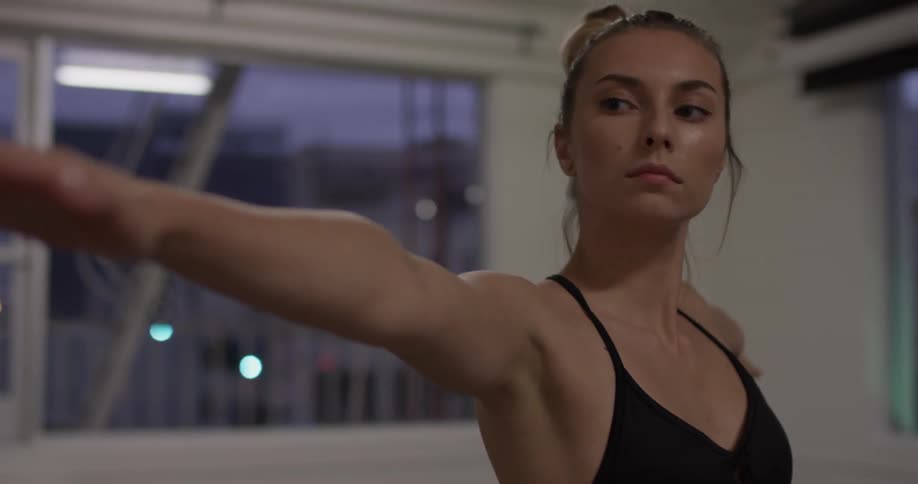Woman practices yoga poses in an empty studio