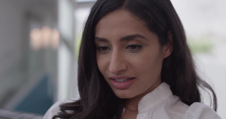 A woman looks down at something and smiles