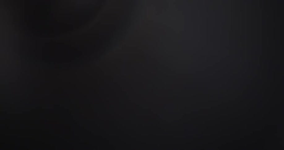 A black background with white smoke or blurry bright objects floating or drifting by creating lens flares and rainbow effects