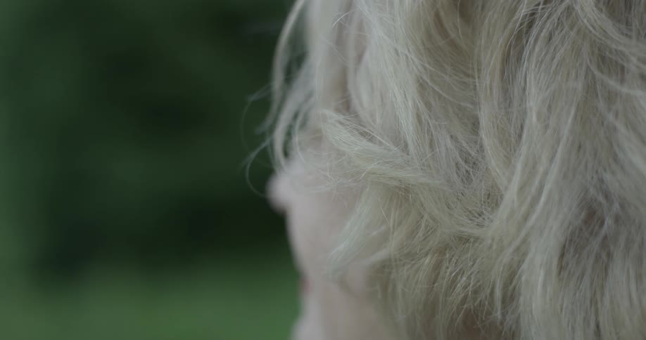 A woman sits and looks out at the natural beauty of the green park ahead of her