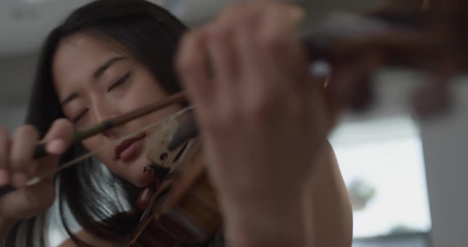 A closeup of a woman playing the violin