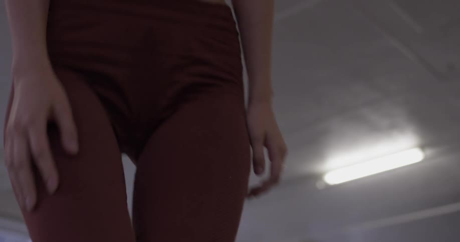 A woman in exercise gear stands and walks off