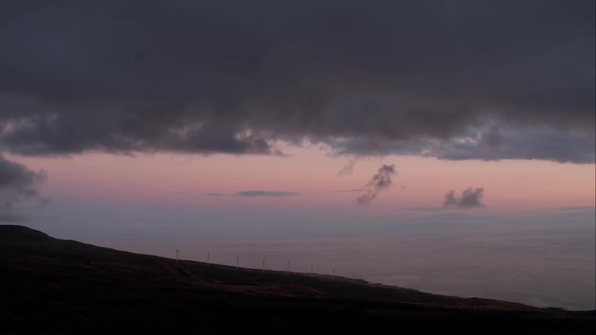 Beautiful purple sky and clouds over a landscape of mountains and flat lands after the sun has set