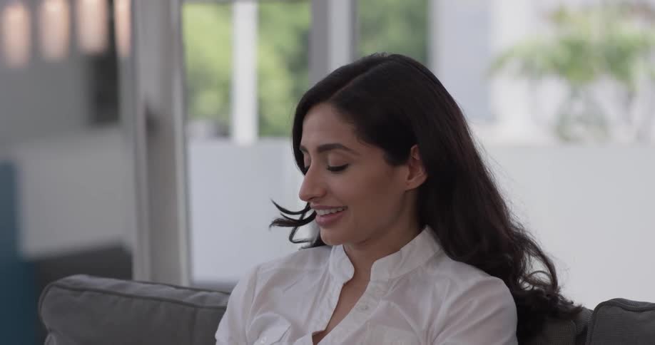 Woman in a room tries out a vr headset before taking it off and relaxing