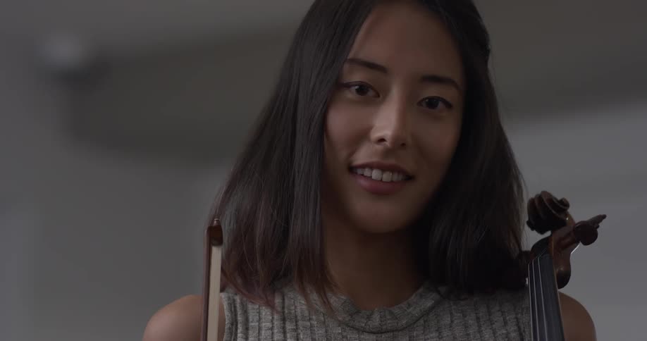 Woman with a violin in her hands smiling