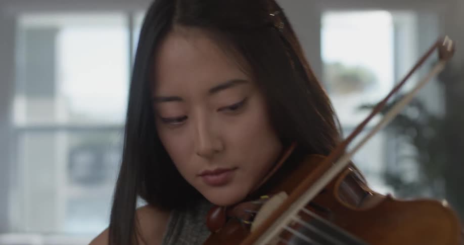 Woman playing a violin in a house