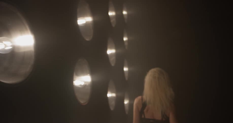 A woman dancing in front of lights