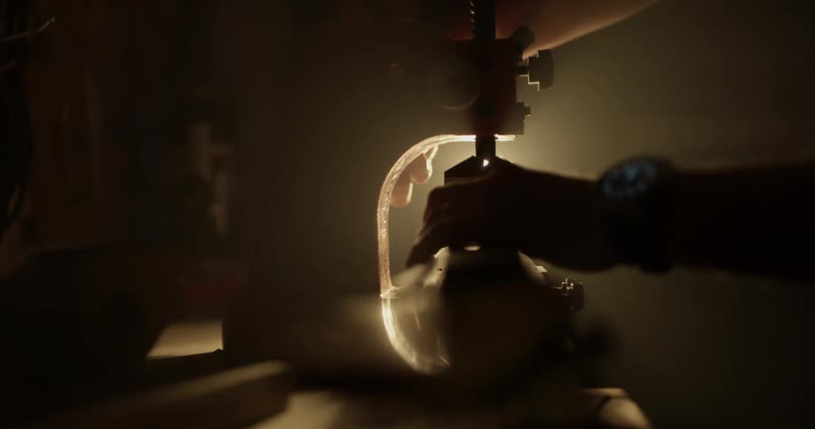 A person lays an object on a piece of machinery