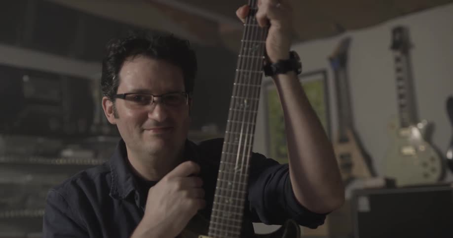 Man Making Guitar In Workshop