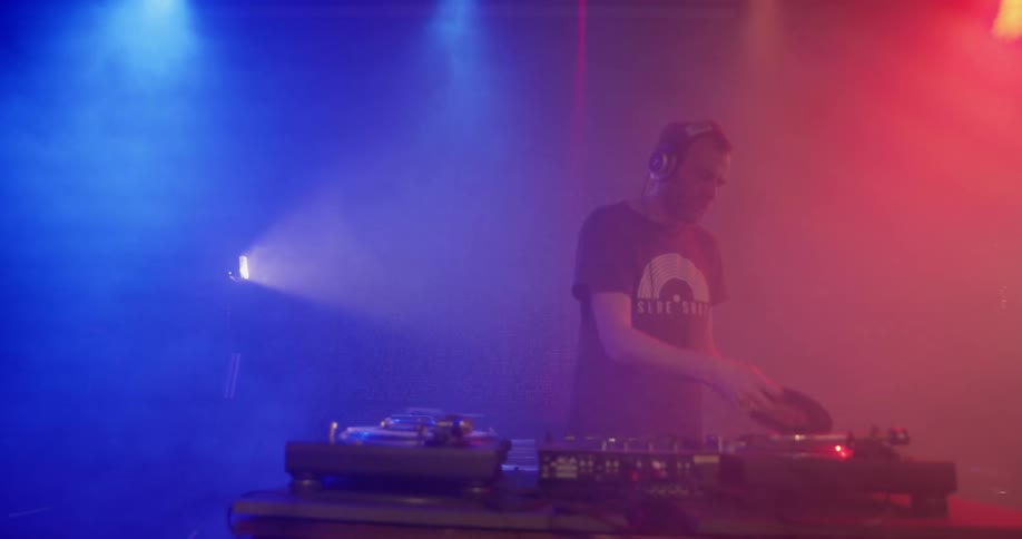 Man djs while lights strobe and fog billows around