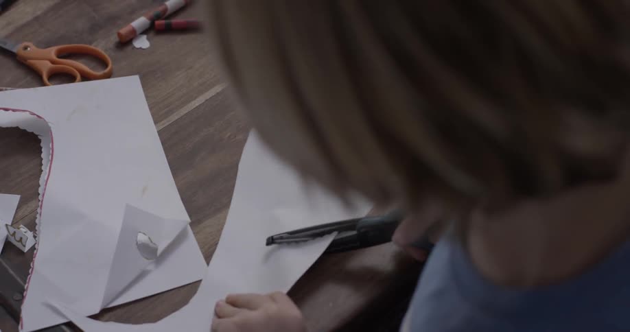 A child cuts shapes out of paper
