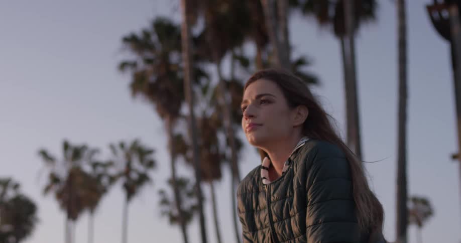 A woman is sitting outside during dusk