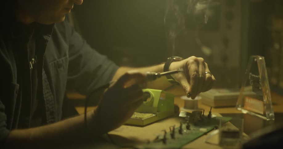 Man Soldering In Garage