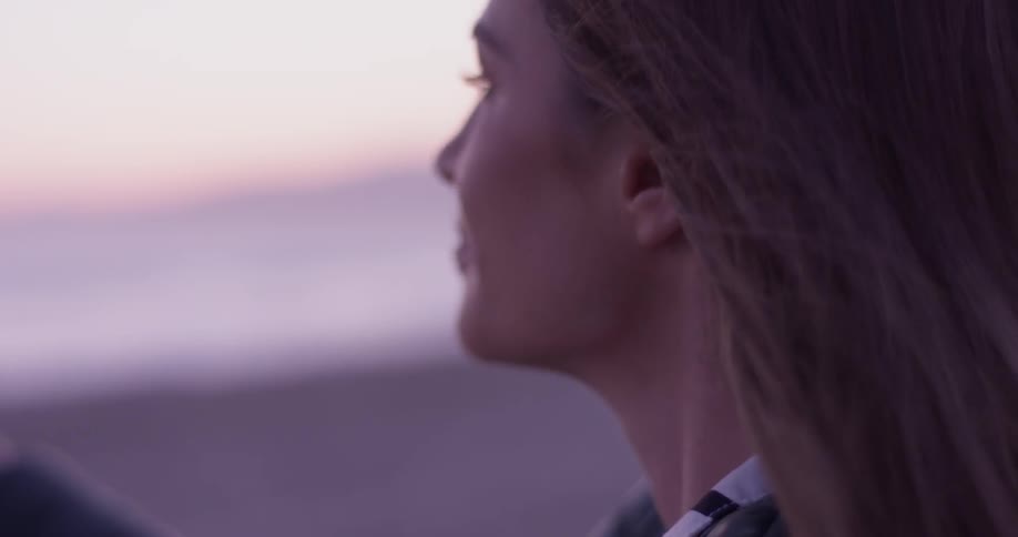 Woman looking at the coast at sunset