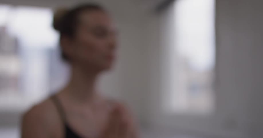 A woman sitting with her hands clapped in front of her