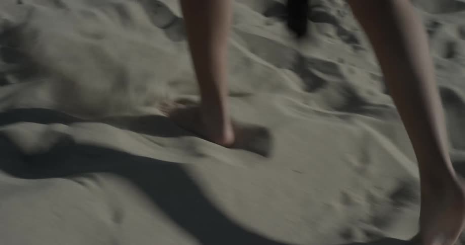 Person walks through sand on a beach
