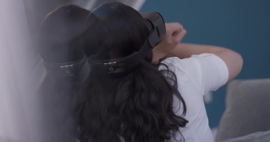 A woman gesticulates wildly while she wears a vr headset
