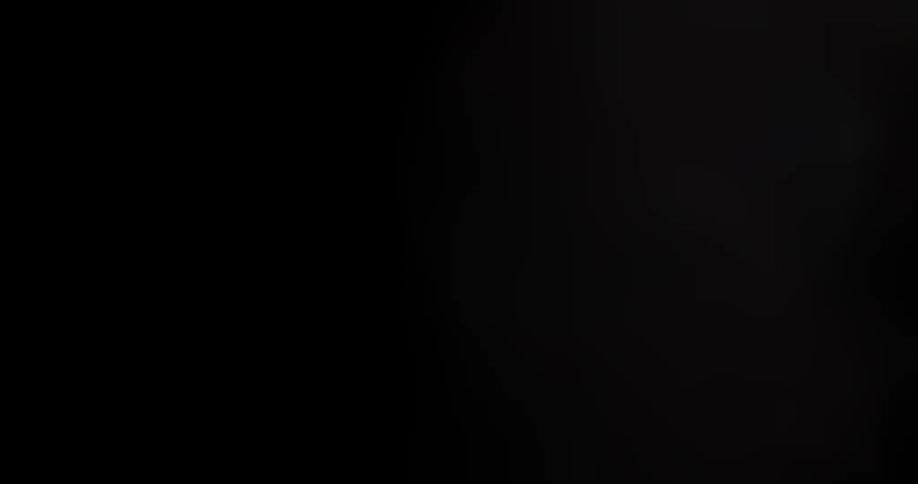 Dark shot of a hint of an object moving back and forth in the background