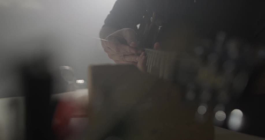 Man Making Guitar In Workshop