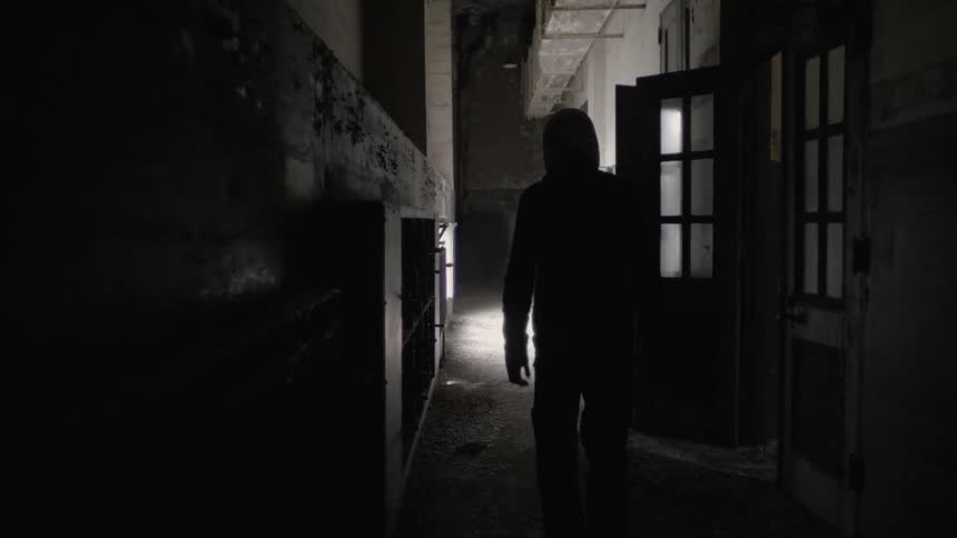 A person walking down a dark hallway