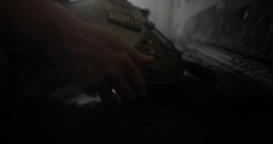 Person pulling a guitar out of a case