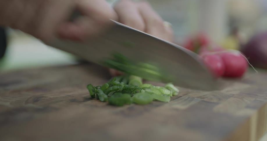 A knife is being used to chop vegetables