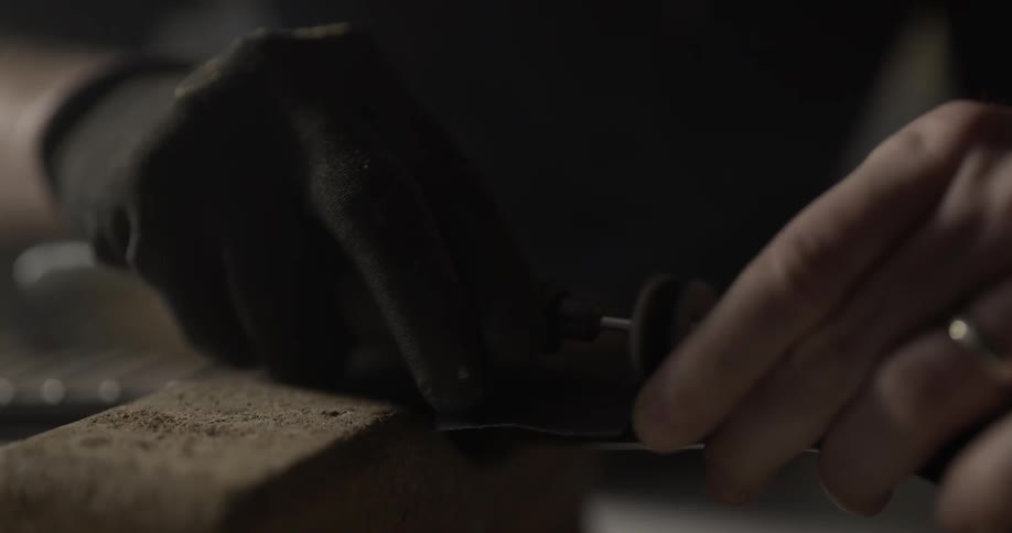 Person sands item with powered tool