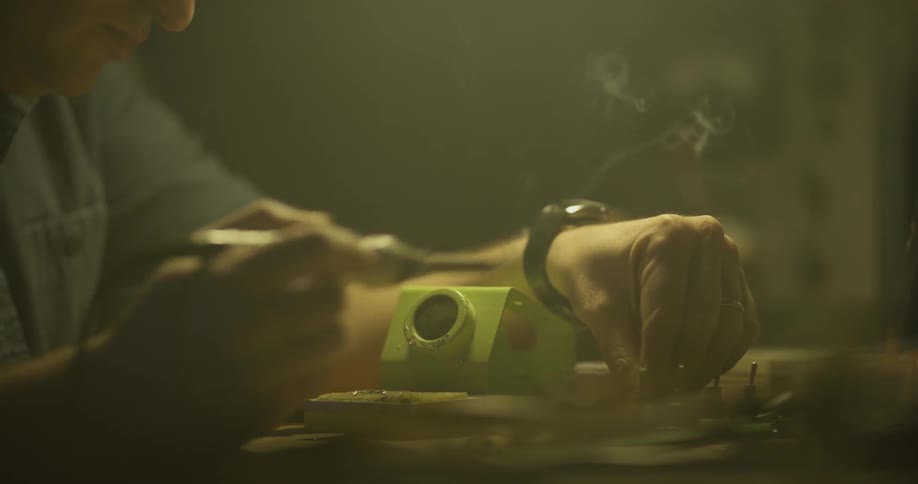 Man Soldering In Garage