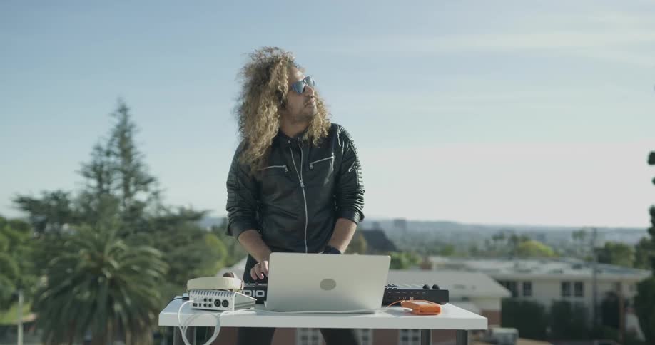 Man plays music on synthesizer on table outside