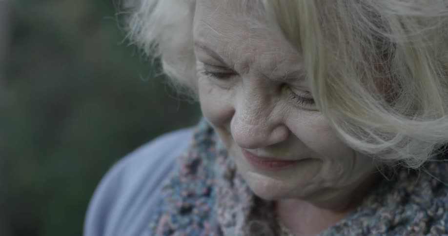 Elderly woman smiles as she looks over something