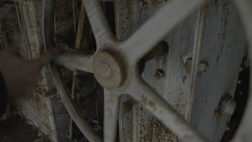 Someone rotates a white spoke to wheel on heavy machinery