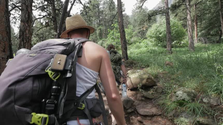 A man is hiking through the woods