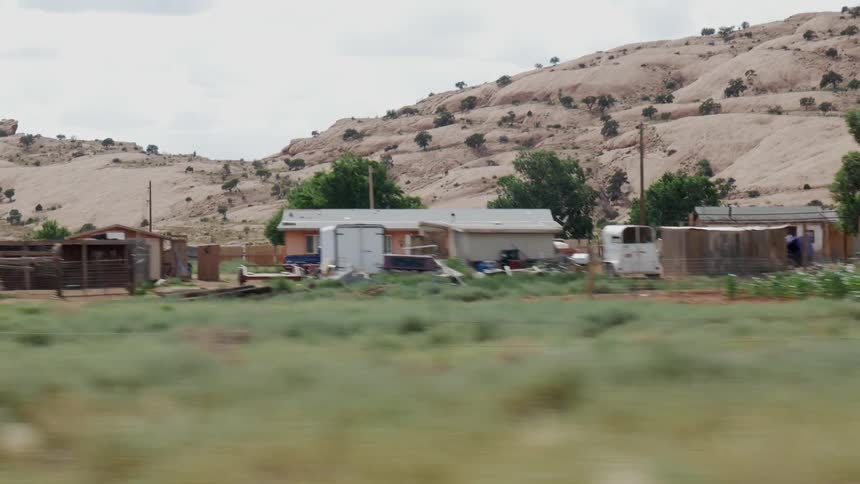 A vehicle driving by homes in a rural area