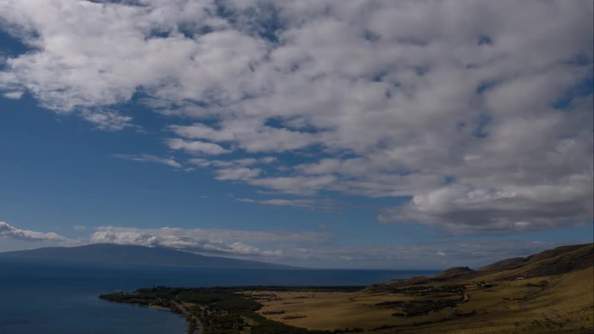 Body of water with mountains in background and partly cloudy skies