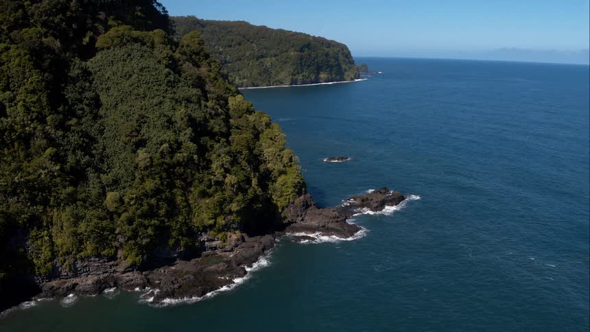 Calm ocean water beside a green hilly island