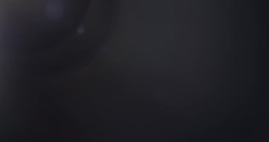 Light shifts around as blurry bright objects pass by in front of a black background creating lens flares