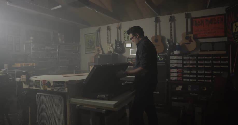Man lays guitar case on table and takes out guitar