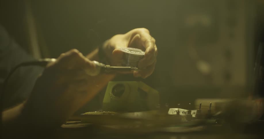 Man Soldering In Garage