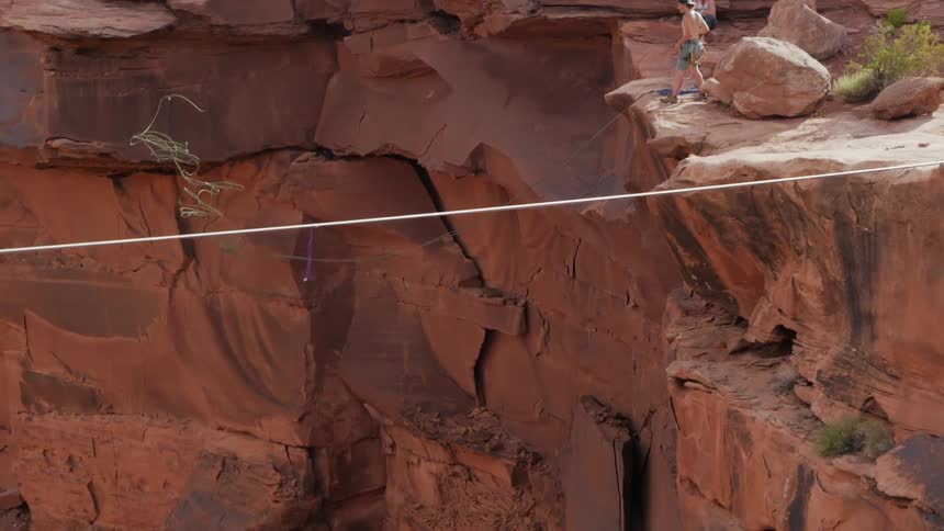 A person throwing a rope into a canyon