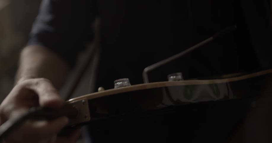 A man plugs in an electric guitar