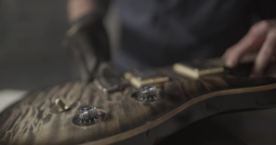 A person polishing a guitar