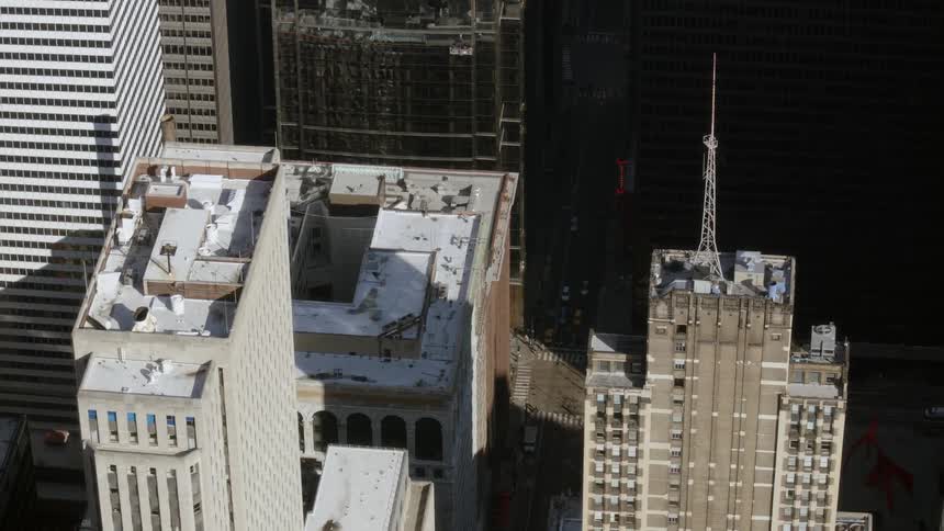 The rooftop of a city building while traffic and pedestrians travel below