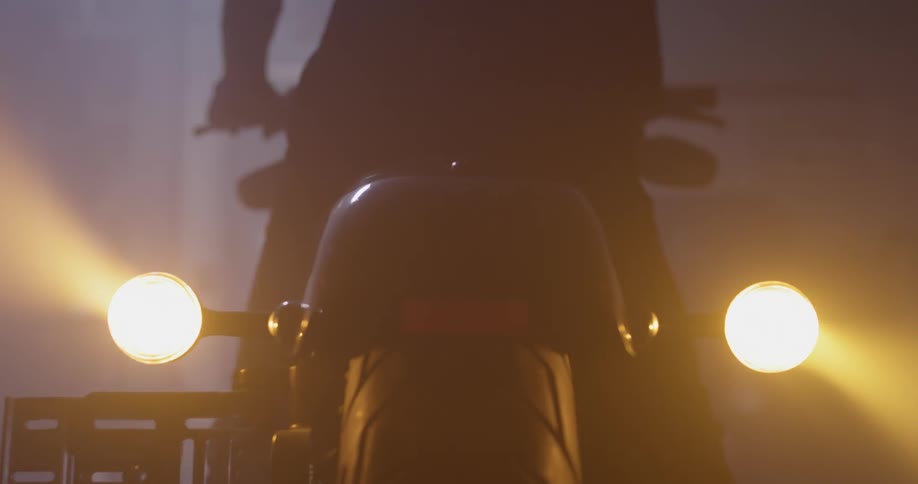 Man mounts motorcycle in garage and turns it on