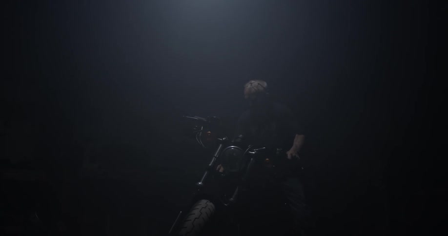 A man gets on a motorcycle and turns it on