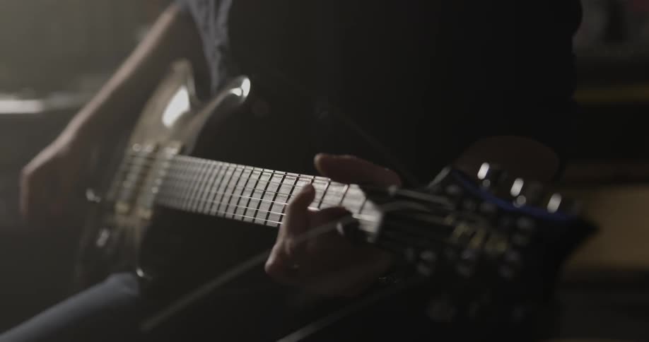 A man is playing guitar and then sets it down