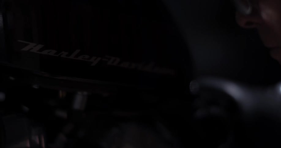 A man works on a harley davidson motorcycle